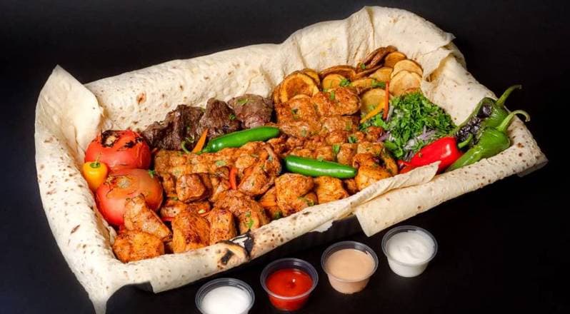 Family combo spread with carved chicken and beef shawarma, rice, hummus, falafel, fries, pita, and toum tubs, Patar Shawarma Glendale