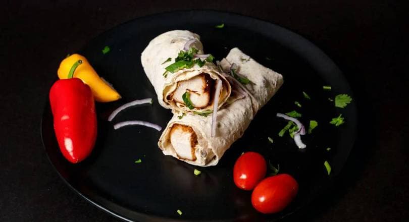 Chicken shawarma carved off the vertical spit, wrapped in lavash with pickles and garlic sauce, Patar Shawarma Glendale