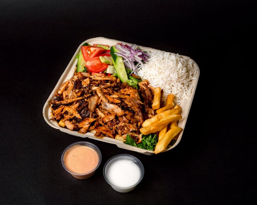 Shawarma plate with carved meat over seasoned rice, salad, pickled turnips, pita, and toum at Patar Shawarma Glendale