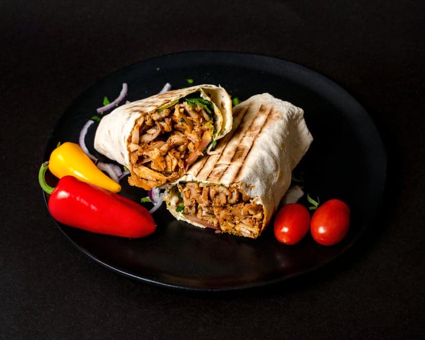 Pressed shawarma wrap in foil, cut to show meat, pickles, and toum inside fresh lavash, Patar Shawarma Glendale